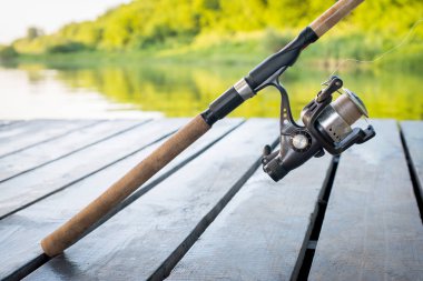 Spinning the rod against the background of the pond professional tool for fishing a predatory fish