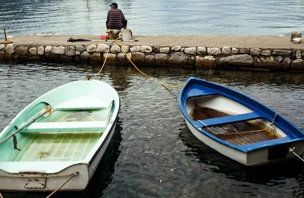 2016年9月21日，黑山多布罗塔：男子坐在码头上钓鱼. — 图库照片