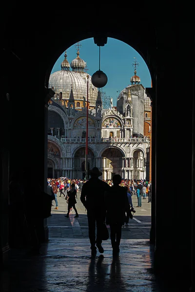 Het silhouet van een paar toeristen voor de St. Marks kathedraal in Venetië. — Stockfoto
