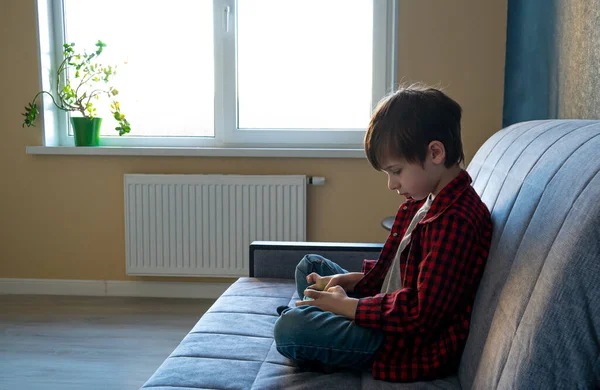Enfocado chico con entusiasmo juega en un teléfono inteligente . — Foto de Stock