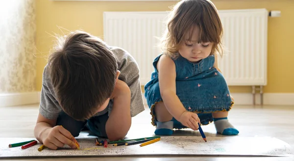 Niños pintan un gran libro para colorear en el suelo — Foto de Stock