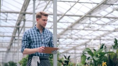 Sera içinde dijital tablet ile çiçekçi.