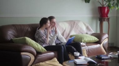 Çift kanepede dizüstü bilgisayar ile oturur