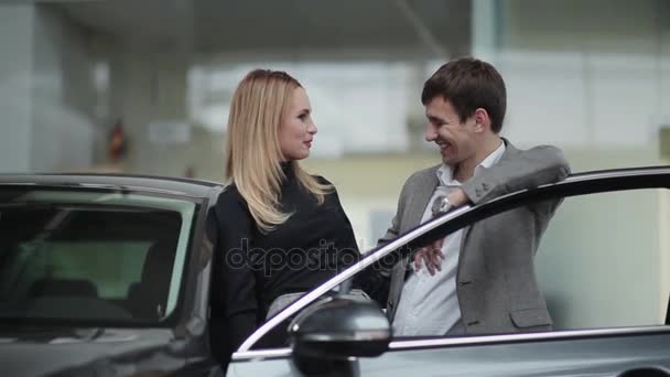 Pareja joven cerca de coche nuevo — Vídeo de stock