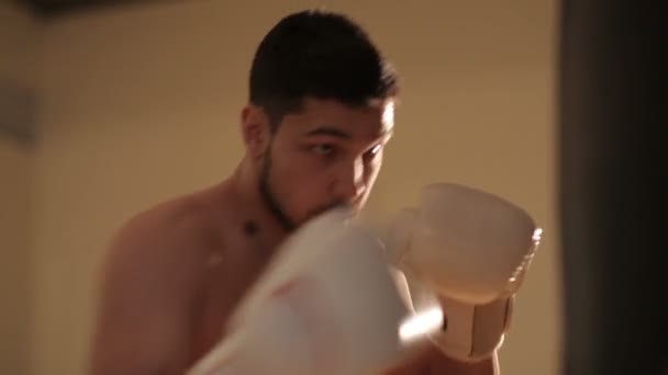 Боксер практикуется на боксерской груше — стоковое видео