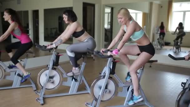 Mujeres montadas en bicicletas estáticas — Vídeo de stock