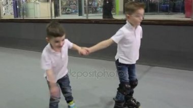 İki küçük çocuğu Silindirler rollerdrome üzerinde sürme. Gülümseyen ve el ele tutuşarak çocuklar.