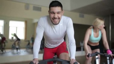 Egzersiz bisikleti üzerinde gülümseyen adam