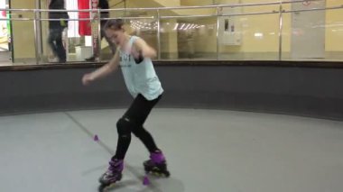 Profesyonel binici bir hileci vasıl rollerdrome yapıyor. Koni hat üzerinden gidiş binici. Kız küçük erkek koniler ile gidiş sonra.