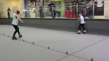 Bir rollerdrome üzerinde silindirler üzerinde yapan kız. Küçük çocuk Süpürgelik yakınındaki sürme ve kız arıyorum.