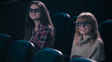 Kadınlar komedi sinema izliyor. Kadın gülüyor ve izlerken sırasında gülümseyen.
