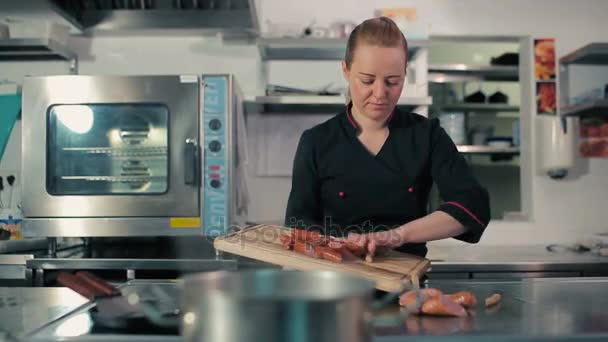 Chef frying frankfurters on stove — Stock Video