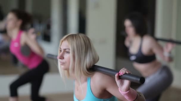 Hermosa mujer en cuclillas con un bar — Vídeo de stock