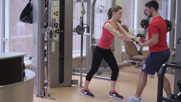 Mujer entrenando en crossover con entrenador — Vídeos de Stock