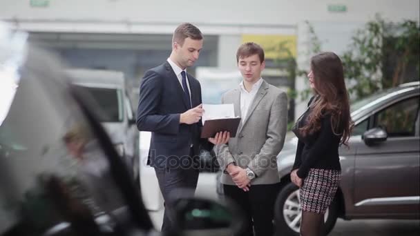 Salesman shows couple information — Stock Video