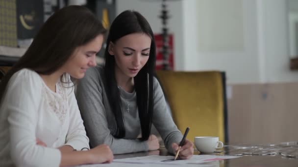 Δύο Νεαρές Γυναίκες Που Κάθεται Ένα Τραπέζι Στο Γραφείο Εργαζομένων — Αρχείο Βίντεο