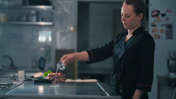 Chef pours oil on stove — Stock Video