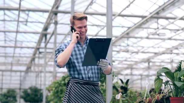 Blumenhändler nimmt telefonische Bestellungen entgegen — Stockvideo