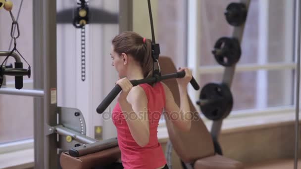 Chica realizando pulldown en el gimnasio . — Vídeos de Stock
