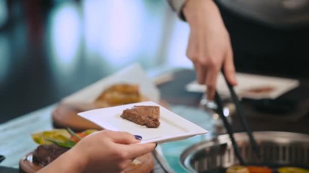 Manos puestas en plato de carne a la parrilla — Vídeos de Stock