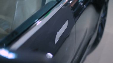 erkek Close-Up el itme modern düğmesini ve yeni siyah araba kapıda aç