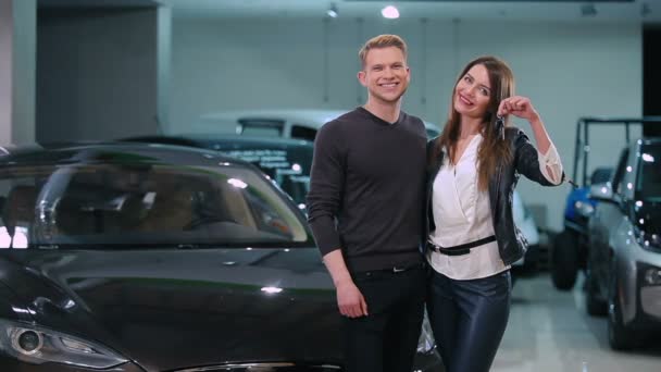 年轻夫妇拿着钥匙从新的现代汽车在经销商 — 图库视频影像