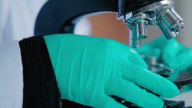 adam mavi eldiven modern laboratuvar mikroskop kullanarak 