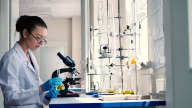modern laboratuvarda çalışan beyaz üniformalı genç esmer kadın 