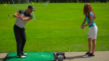 genç adam ve kadın golf golf kulübünde yeşil çimenlerin üzerinde oynamak 