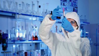 beyaz üniforma, maske ve mavi eldiven modern laboratuvar kan ile çalışan genç kadın 