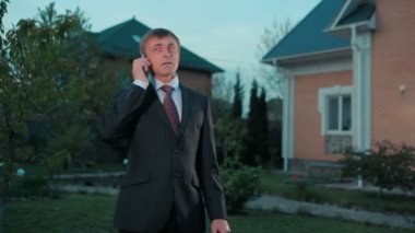 takım elbise arka bina telefon kullanarak mutlu işadamı