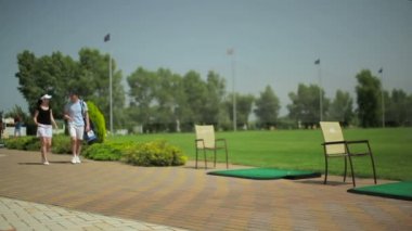 genç adam ve yeşil çim golf Club yakınındaki yolda yürüyen kadın