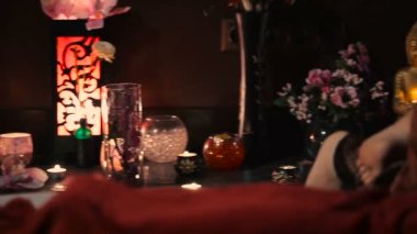 Asyalı kadın kırmızı üniformalı spa salonda geleneksel Tay masajı yapıyor