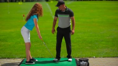 genç adam ve kadın golf golf kulübünde yeşil çimenlerin üzerinde oynamak  