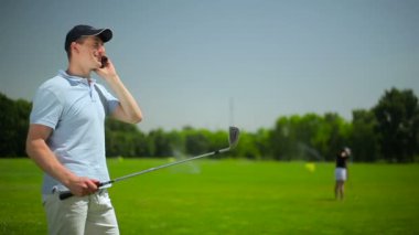 genç adam ve kadın golf golf kulübünde yeşil çimenlerin üzerinde oynamak  