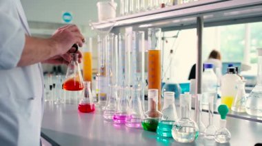test tüpleri mavi likörün insanlar beyaz modern laboratuvar arka planda üniforma ile yakın çekim