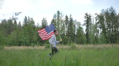 çalışan ve açık havada doğa üzerinde yeşil orman, Amerikan bayrağı tutarak yakışıklı  
