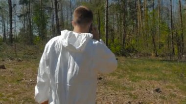 Telefonunuzun ve güneşli gün ormanda beyaz Üniformalı erkeklere 