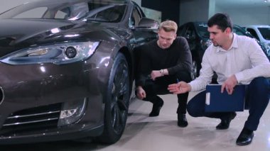 modern Siyah araba erkek gösteren tekerlek. İstemci içinde araba Bayilik yardımcı satış Yöneticisi.