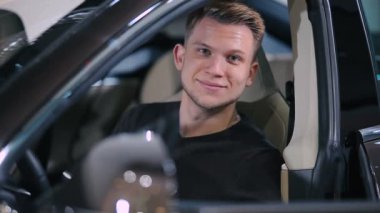 Siyah kazaklı yeni modern arabaya başparmak gösterilmesini yakışıklı delikanlı Close-Up