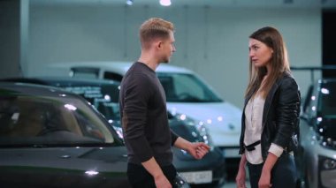 Genç çift yeni modern araba Bayilik yakınındaki söz