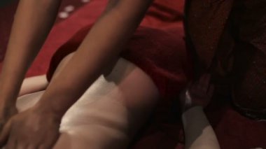 Asyalı kadın kırmızı üniformalı yağ spa salonda ile geleneksel Tay masajı yapıyor