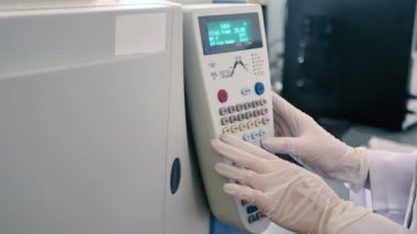 Beyaz üniformalı kadın modern laboratuarda bilgisayarla çalışıyor. 