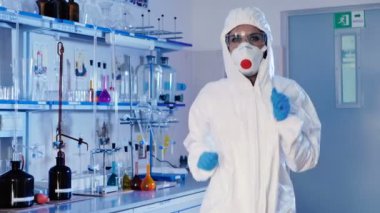 genç kadın beyaz üniforma, maske ve mavi eldiven modern laboratuvarda dans. 
