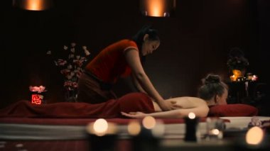 Asyalı kadın kırmızı üniformalı spa salonda geleneksel Tay masajı yapıyor