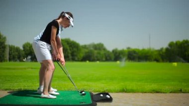 genç adam ve kadın golf golf kulübünde yeşil çimenlerin üzerinde oynamak 