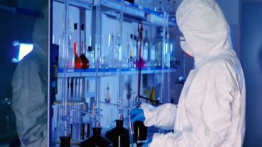 beyaz üniforma genç kadın, maske ve modern laboratuvarda çalışan mavi eldiven 