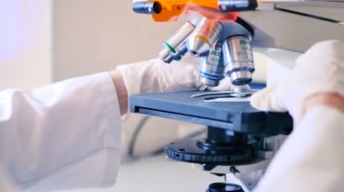 modern laboratuar mikroskobu ile çalışan beyaz üniformalı kadın 