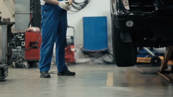 Mecánico sujetar la rueda en el coche — Vídeos de Stock