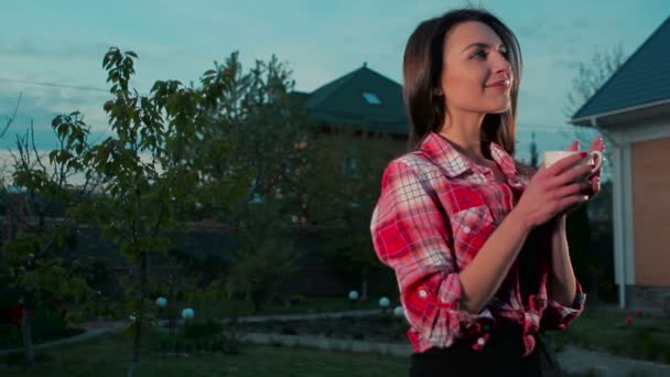 Młoda Piękna Kobieta Trzymając Kubek Gorącej Kawy Zewnątrz Pobliżu Domu — Wideo stockowe